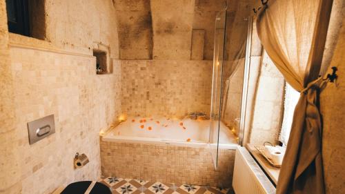 a bathroom with a bath tub and a shower at Cappadocia Old Houses in Nevsehir