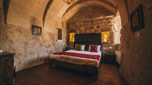 a bedroom with a bed in a stone room at Cappadocia Old Houses in Nevsehir