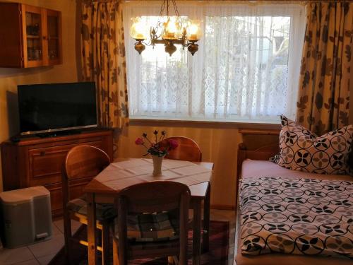 a living room with a table and a couch and a television at Bungalow Poggendorf in Eldena