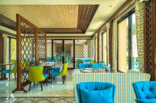 a restaurant with blue and yellow tables and chairs at Ataman Luxury Villas in Ko Kho Khao