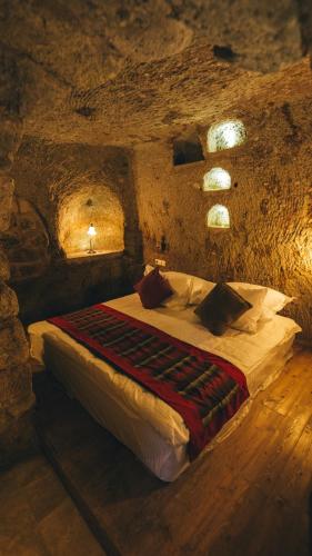 a bedroom with a bed in a stone room at Cappadocia Old Houses in Nevsehir