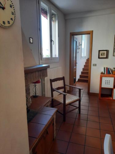 a living room with a clock on the wall and a chair at Cà Rossa in Imola