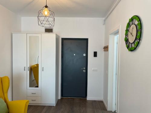 a hallway with a blue door and a clock on the wall at Apartcentral in Baia Mare
