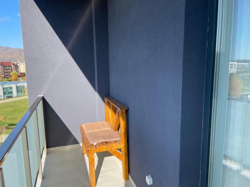 a wooden chair sitting on the side of a staircase at Apartcentral in Baia Mare