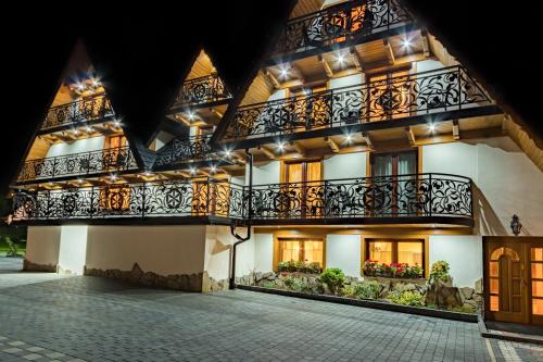 a building with balconies and lights on it at Leśny Dwór in Murzasichle