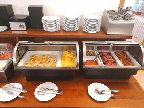a buffet with plates of food on a table at Hotel Belcredi in Brno