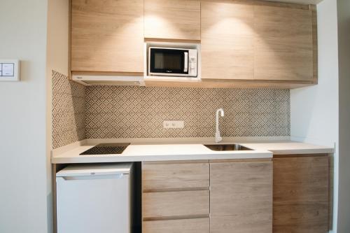 a small kitchen with a sink and a microwave at The White Apartments in San Antonio