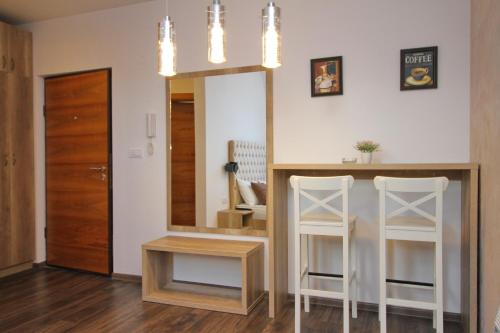 a kitchen with a mirror and two white stools at All Seasons Residence in Zlatibor