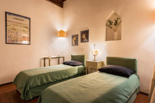 a room with two beds and a table with a lamp at Pitti Studio by Mmega in Florence
