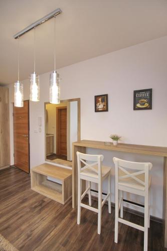 a kitchen with a table and two white chairs at All Seasons Residence in Zlatibor