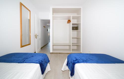 Habitación blanca con 2 camas y espejo. en Apartamentos Monte Verde, en Puerto Rico de Gran Canaria