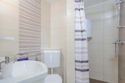 une salle de bain avec toilettes, lavabo et douche dans l'établissement Apartments Mokalo, à Orebić