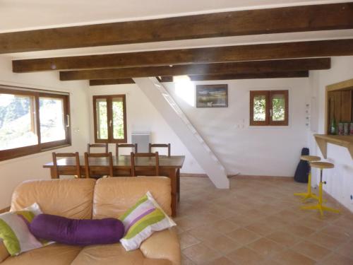 a living room with a couch and a staircase at La Miellerie des Nuages in Prads-Haute-Bléone