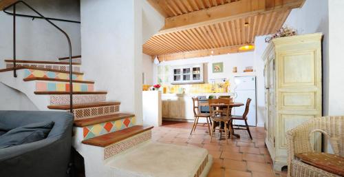 a living room with a staircase and a kitchen with a table at Domaine Faverot in Maubec