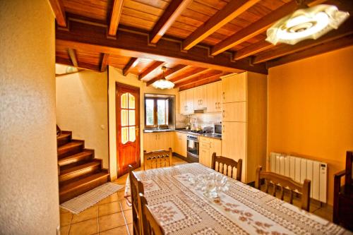a dining room with a table and a kitchen at Casa Marcelino in Muxia