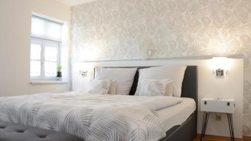 - une chambre dotée d'un grand lit avec des draps blancs et une fenêtre dans l'établissement Rosenwinkel Appartement im OG, à Halberstadt
