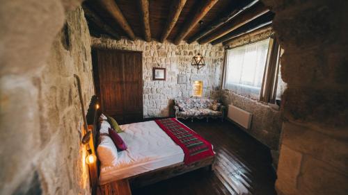 a bedroom with a bed in a stone building at Cappadocia Old Houses in Nevsehir