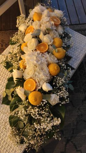 a bouquet of flowers and oranges on a bench at Rouge Hotel International in Milano Marittima