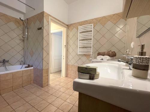 a bathroom with a sink and a shower and a tub at Nissaki Jonas Apartment in Nisaki