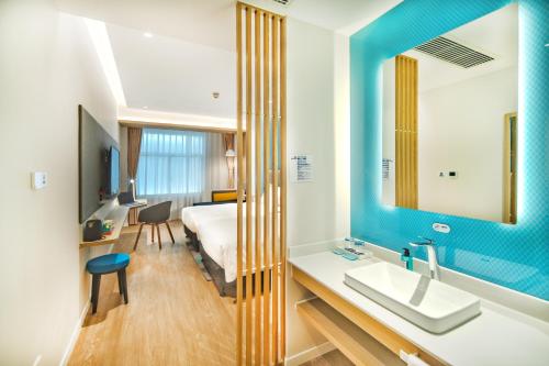 Holiday Inn Express Shanghai Pudong Zhangjiang, an IHG Hotel في شانغهاي: حمام فيه سرير ومغسلة ومرآة