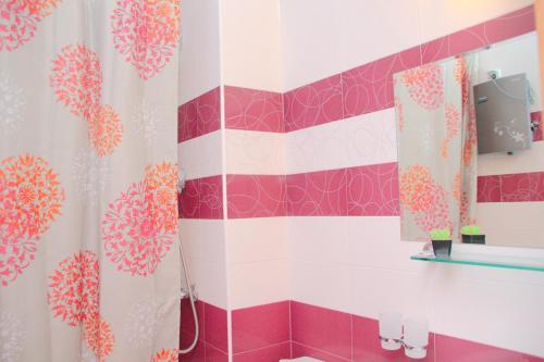 a bathroom with a pink and white shower curtain at Гранд Манастира Апартаменти "Зимна приказка" in Pamporovo
