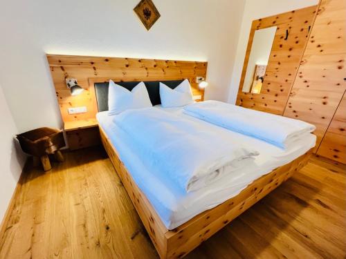 een slaapkamer met een groot bed met een houten hoofdeinde bij Tiroler Zeitgeist Apartment Fügen in Fügen