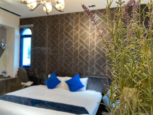 a bedroom with a bed with blue pillows at Bohemia in Jian