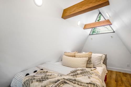 a attic bedroom with a bed and a window at Unique A-frame Tiny House in Houston Central in Houston