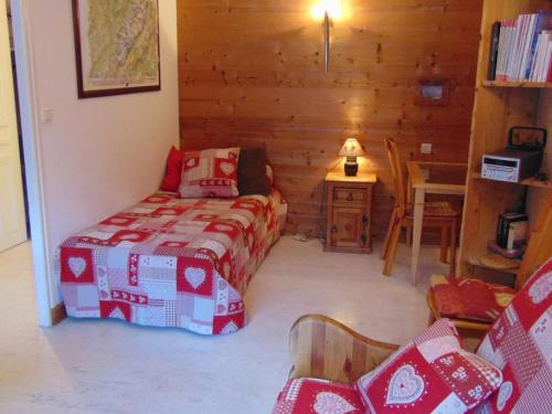 a room with a bed and a table with a chair at Studio Chamonix-Mont-Blanc, 1 pièce, 3 personnes - FR-1-517-27 in Chamonix