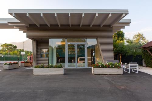 a building with awning and flowers in front of it at Camping Del Sole Village in Iseo