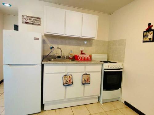 a kitchen with a white refrigerator and a sink at Free WIFI 1st Floor Apartment in Punta Santiago