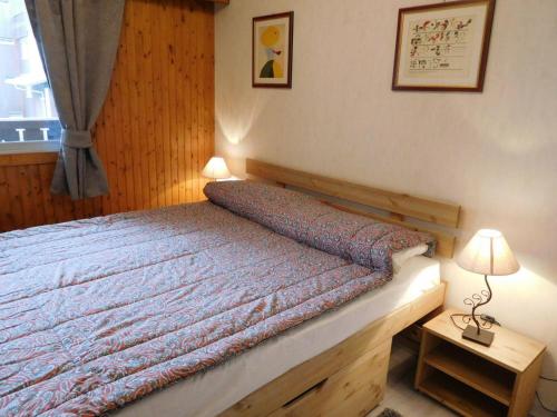 een slaapkamer met een bed en een tafel met een lamp bij Appartement Chamonix-Mont-Blanc, 2 pièces, 5 personnes - FR-1-517-39 in Chamonix-Mont-Blanc