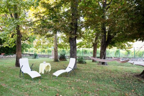 two chairs and a table in a park with trees at Villa Guarienti Valpolicella in Fumane