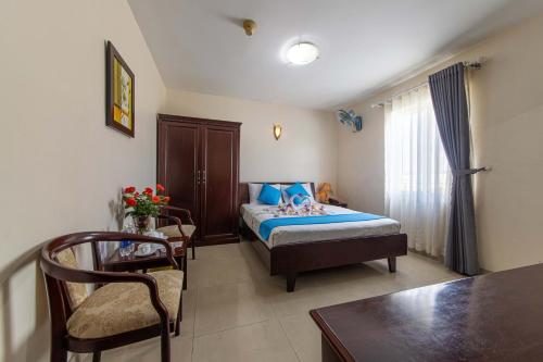 Phong Lan 2 Hotel في مدينة هوشي منه: غرفة نوم بسرير وطاولة وكرسي