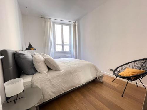 a bedroom with a bed and a chair and a window at Appartamento Gasparo da Salò in Salò