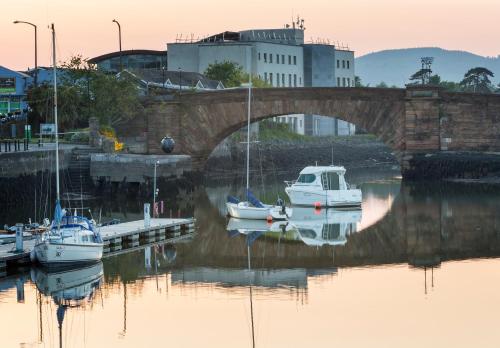 a group of boats docked in the water under a bridge at Lawlors Hotel Dungarvan in Dungarvan