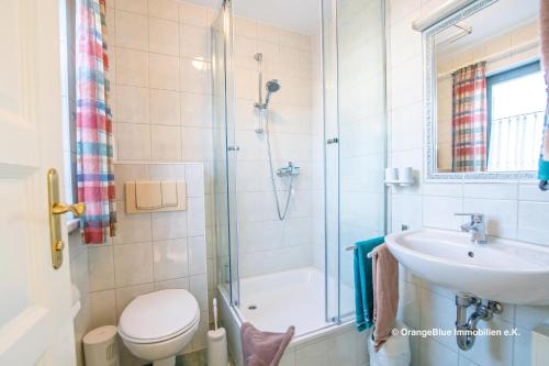een badkamer met een douche, een toilet en een wastafel bij Ferienwohnung Seestraße 67 in Zingst