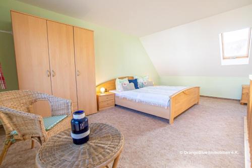 een slaapkamer met een bed, een stoel en een tafel bij Ferienwohnung Seestraße 67 in Zingst