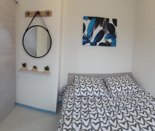 Schlafzimmer mit einem Bett und einem Spiegel in der Unterkunft Maison La prairie porte de Chambord in Thoury