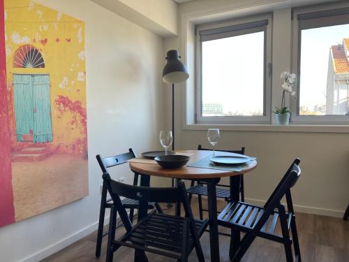 uma sala de jantar com uma mesa e cadeiras e duas janelas em Superb Loft 899 no Porto