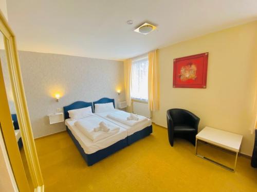 Habitación de hotel con cama y silla en Hotel Grimm en Kassel