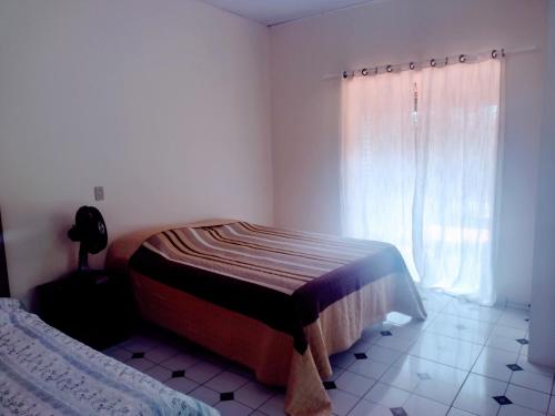 a bedroom with a bed and a window at Suits - Canto do sabia in Brotas