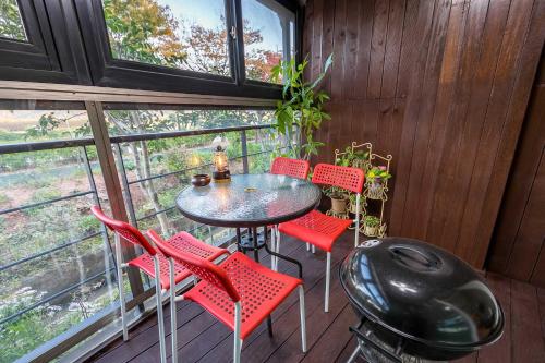 a room with a table and chairs on a balcony at Four Seasons Pension in Suncheon