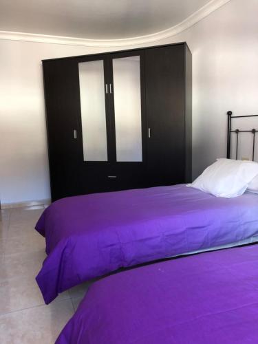 a bed with purple sheets in a bedroom at Mederos 20 in Los Llanos de Aridane