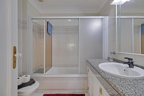 ヴィラモウラにあるVilamoura Main Avenue by Homingのシャワー、洗面台、トイレ付きのバスルーム