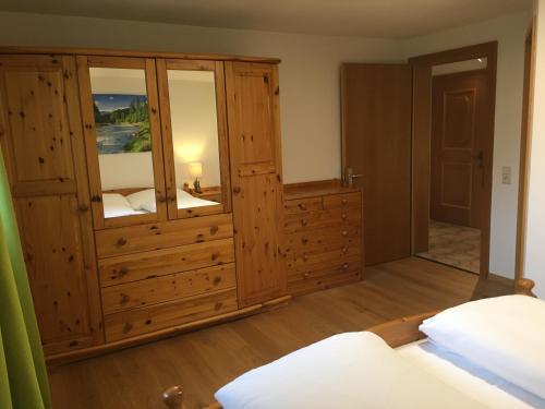 a bedroom with a large wooden cabinet and a bed at Ferienwohnung Thöny Vandans in Vandans