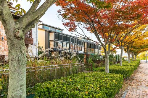 a house with a fence and trees in front of it at Four Seasons Pension in Suncheon