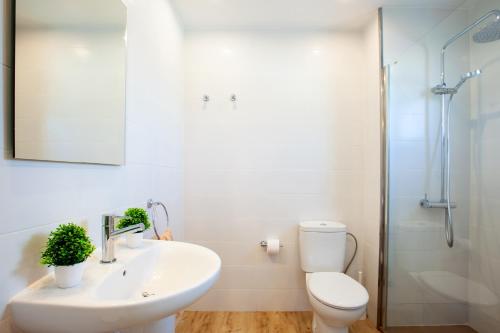Un baño con lavabo, inodoro y ducha. en Costa Luz 5 Trioblancos, en Tías
