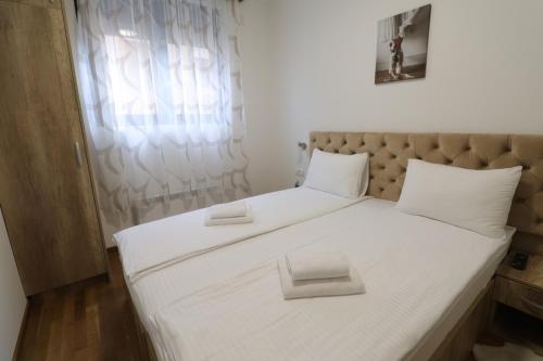 a large white bed with two white pillows on it at All Seasons Residence in Zlatibor