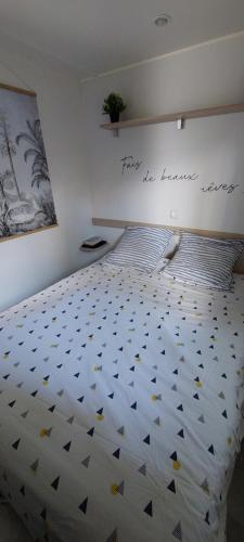 1 dormitorio con 1 cama con un cartel en la pared en Mobil home climatisé Carnac en Carnac